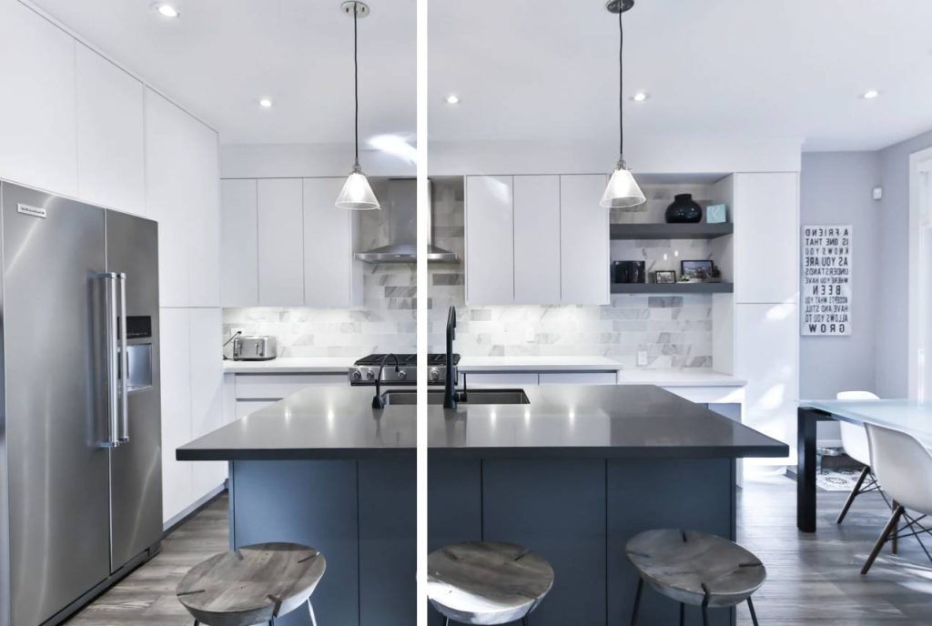 A contemporary kitchen with built-in appliances, white handleless cabinets, pendant lighting, and a kitchen island with a blue base and black tabletop