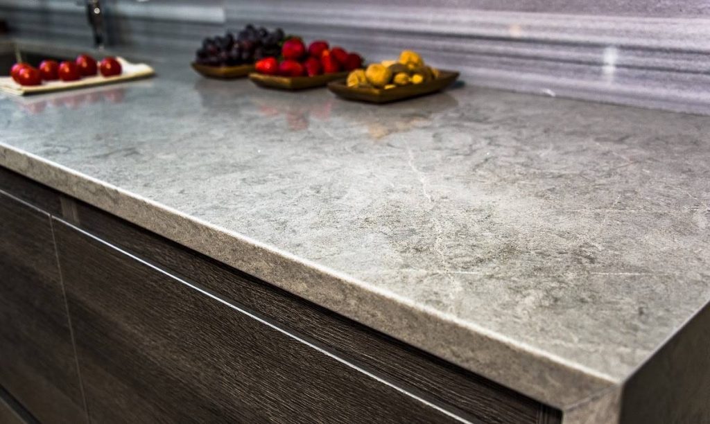 a matte-finished gray granite countertop with white and gray veining and fruits on top