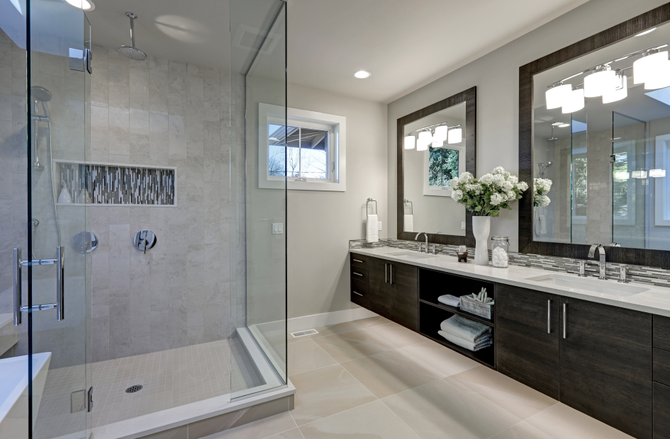 a bathroom with a glass-enclosed shower and two vanity mirrors over the white bathroom counters