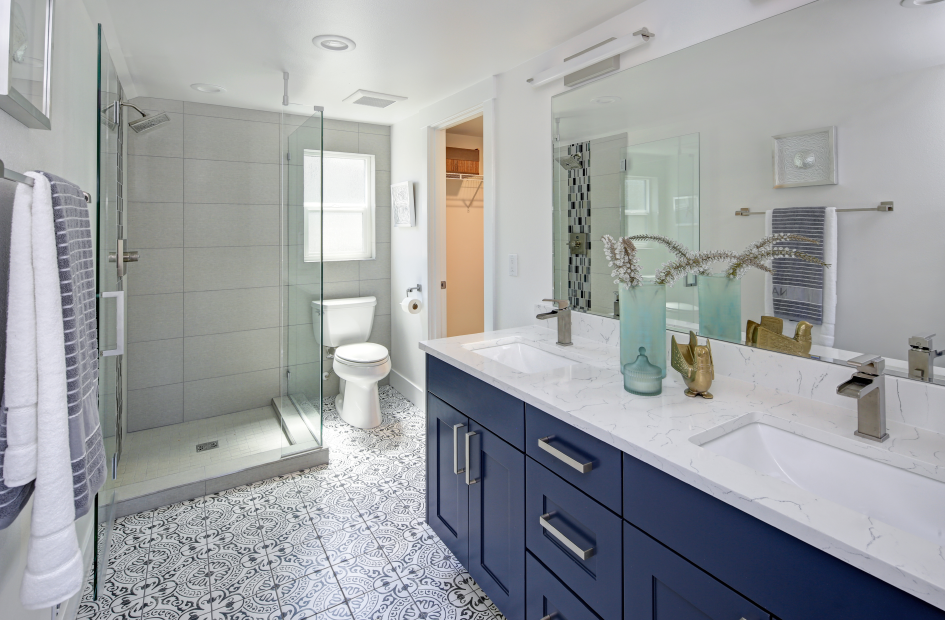 a spacious bathroom with a large vanity mirror over the white countertop above the blue bathroom cabinets
