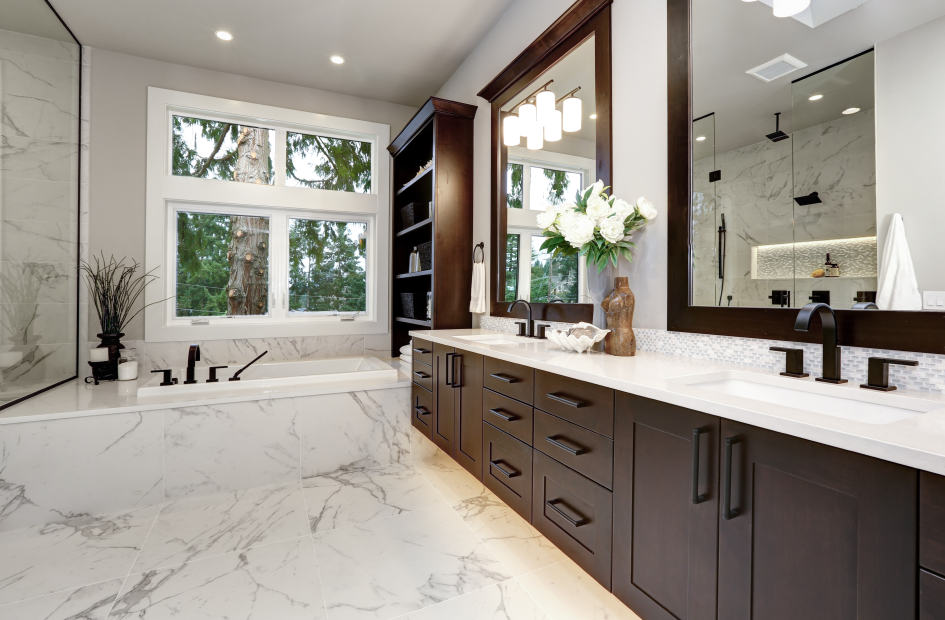 a bathroom with white marble floors, a bathtub, and a brown wooden shelf next to the vanity area with a white countertop, mirror, and dark brown cabinets.
