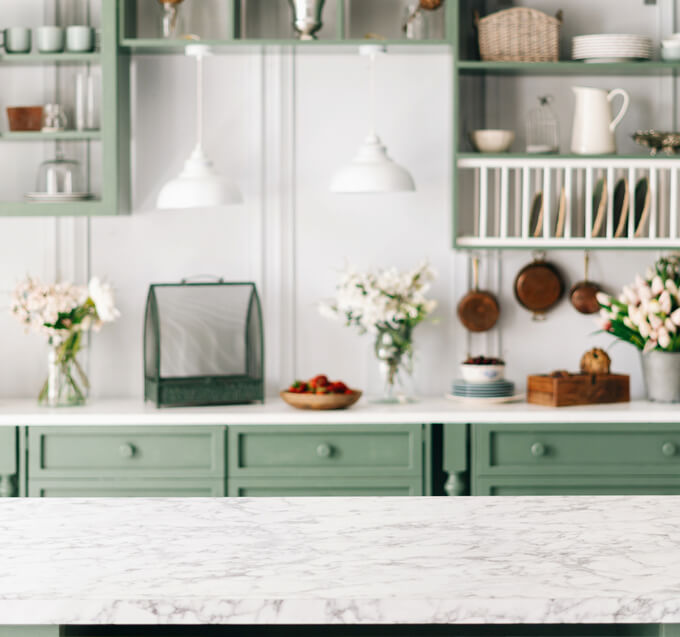 White countertops in mint green kitchen.
