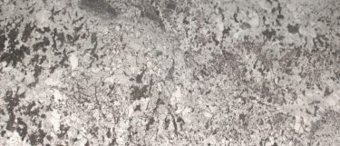 a white splendor granite countertop surface that features a white base covered in rich, dark, gray veining